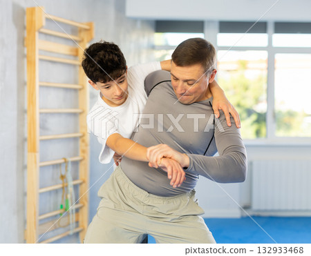 Teenage boy and middle-aged man training throwing method during self-defense courses Teenage boy and middle-aged man training throwing method during self-defense courses 132933468