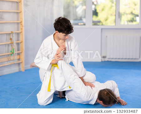 Man and teenage boy train judo fighting techniques Man and teenage boy train judo fighting techniques 132933487