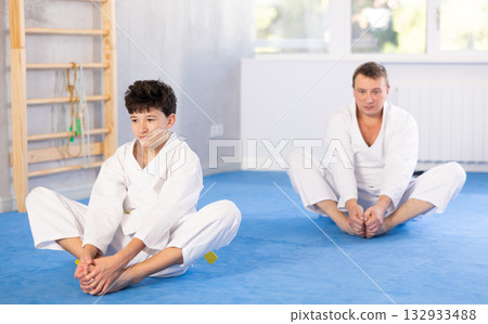 Man and boy teenager doing butterfly exercises 132933488