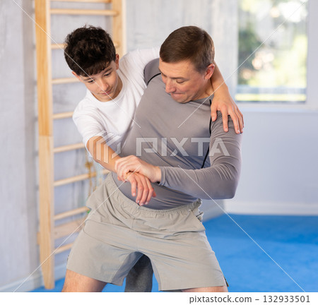 Teenage boy and middle-aged man training throwing method during self-defense courses Teenage boy and middle-aged man training throwing method during self-defense courses 132933501