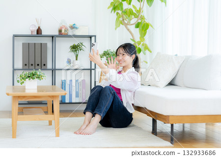 在房間裡操作智慧型手機的年輕女子 132933686