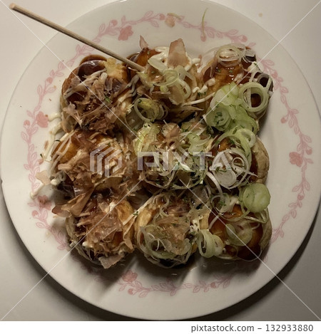Takoyaki, a popular Japanese street food, are crispy round dough balls filled with octopus, tempura bits, and pickled ginger, topped with takoyaki sauce, bonito flakes, and aonori. Takoyaki, a popular Japanese street food, are crispy round dough balls filled with octopus, tempura bits, and pickled ginger, topped with takoyaki sauce, bonito flakes, and aonori. 132933880