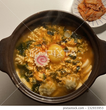 Steaming hot ramyun with rich, savory broth and chewy noodles, paired with spicy, tangy kimchi. A perfect Korean comfort food combination, balancing bold flavors and satisfying textures. Steaming hot ramyun with rich, savory broth and chewy noodles, paired with spicy, tangy kimchi. A perfect Korean comfort food combination, balancing bold flavors and satisfying textures. 132933953