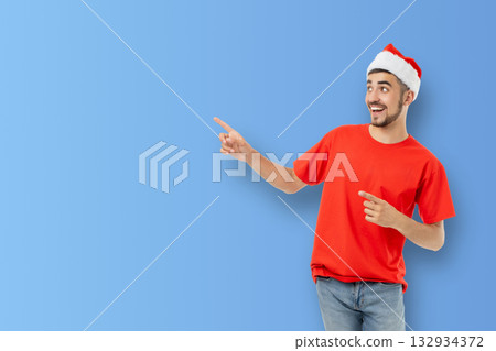 Young man in a Santa hat enthusiastically gestures 132934372