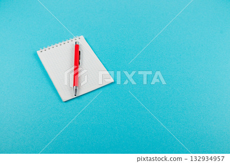 Notebook and pen on a blue background ready for ideas and notes Notebook and pen on a blue background ready for ideas and notes 132934957