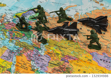 Toy soldiers and jets staged on a colorful world map Toy soldiers and jets staged on a colorful world map 132934986