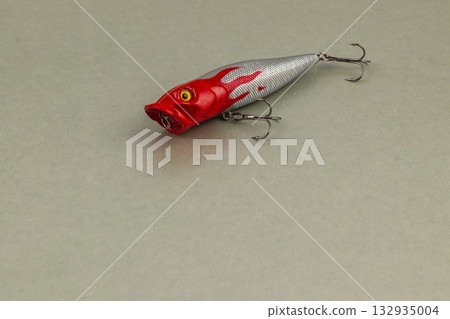 Colorful fishing lure resting on a smooth surface indoors Colorful fishing lure resting on a smooth surface indoors 132935004