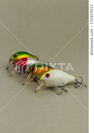 Colorful fishing lures displayed on a neutral surface for anglers 132935015
