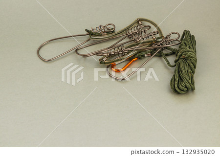 Fishing gear including hooks and rope on a flat surface for outdoor activities 132935020
