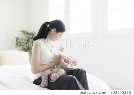 Mother giving milk to her baby 132935288