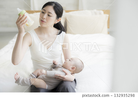 Mother giving milk to her baby 132935298