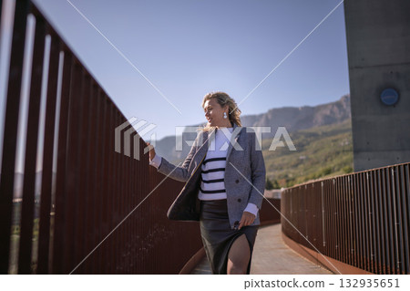 Woman blazer walking modern bridge structure stylish outfit mountains background copy space 132935651