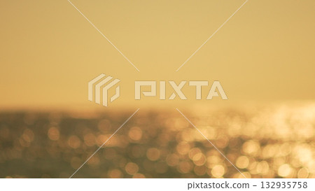Bokeh Sunset Ocean: Golden sunlight shimmering on blurred ocean waves at dusk, creating sparkling reflections. Bokeh Sunset Ocean: Golden sunlight shimmering on blurred ocean waves at dusk, creating sparkling reflections. 132935758