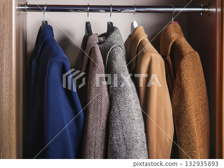 衣櫃裡有幾件藍棕色的針織外套和夾克。 132935893