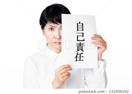 一位身穿白襯衫的老婦人怒視著一張寫著「個人責任」的紙。 132936392