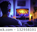 Person Watching Colorful TV Screen in Cozy Living Room Environment 132938101