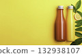 Fresh Juice Bottles with Citrus Leaves on Bright Yellow Background 132938107