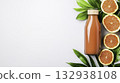Fresh Citrus Juice in Glass Bottle Surrounded by Vibrant Green Leaves 132938108