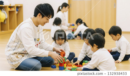 A scene of nursery teachers and children playing with building blocks indoors A scene of nursery teachers and children playing with building blocks indoors 132938433