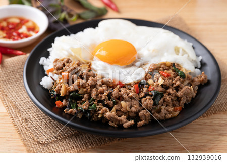 Thai food, Stir fried holy basil with minced pork with cooked rice and fried egg on top Thai food, Stir fried holy basil with minced pork with cooked rice and fried egg on top 132939016