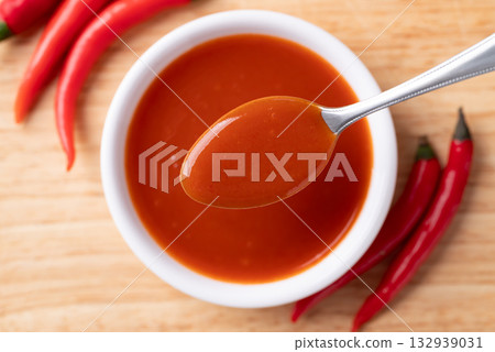 Sriracha sauce in a bowl with spoon on wooden background, Chili sauce, Table top view 132939031