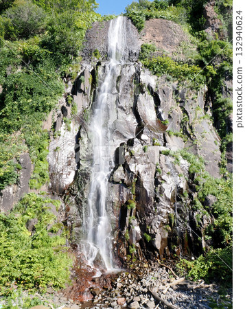 Silver waterfall cascading down from a cliff Silver waterfall cascading down from a cliff 132940624