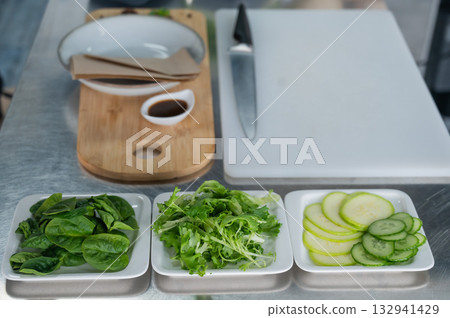 Making a flatbread with herbs in a cafe. Making a flatbread with herbs in a cafe. 132941429