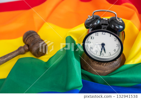 Judge's gavel and alarm clock on a rainbow flag. Judge's gavel and alarm clock on a rainbow flag. 132941538