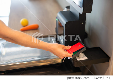 Woman paying with credit card at self-checkout. Woman paying with credit card at self-checkout. 132941964