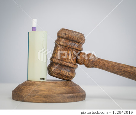 Judge's gavel and e-cigarette. Smoking ban. Tobacco heating systems. Judge's gavel and e-cigarette. Smoking ban. Tobacco heating systems. 132942019