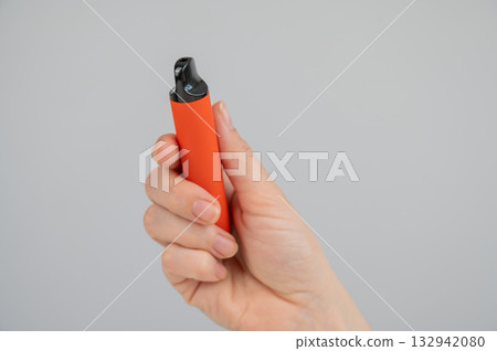 Woman holding disposable vape on white background. Copy space.  132942080
