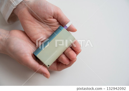 Woman holding electronic cigarette on white background. Tobacco heating systems. 132942092