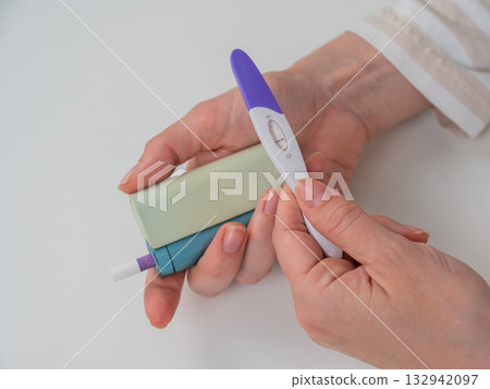Woman holding pregnancy test and e-cigarette. Woman holding pregnancy test and e-cigarette. 132942097
