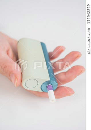 Woman holding electronic cigarette on white background. Tobacco heating systems. 132942269