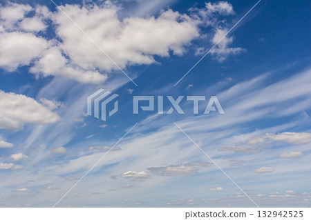 Vast blue sky with wispy clouds stretching across the horizon during a sunny day 132942525