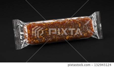 Energy Bar in Transparent Packaging on Black Background, Close-up Shot Energy Bar in Transparent Packaging on Black Background, Close-up Shot 132943124