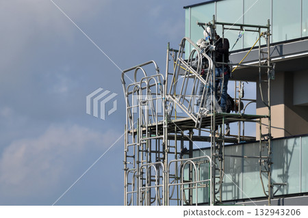 Construction site: Newly built apartment building: Temporary scaffolding being dismantled Construction site: Newly built apartment building: Temporary scaffolding being dismantled 132943206