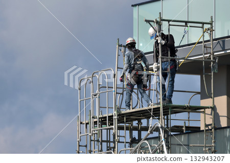 Construction site: Newly built apartment building: Temporary scaffolding being dismantled Construction site: Newly built apartment building: Temporary scaffolding being dismantled 132943207