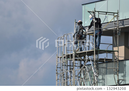 Construction site: Newly built apartment building: Temporary scaffolding being dismantled Construction site: Newly built apartment building: Temporary scaffolding being dismantled 132943208