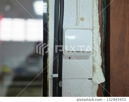White Light Switch Mounted on Textured Wall 132943453