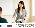 A Japanese female lecturer distributing materials and giving explanations 132943529