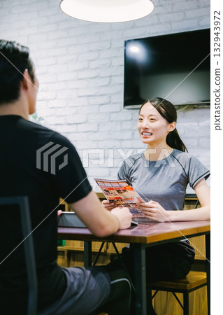A woman receiving membership information at a sports gym 132943972