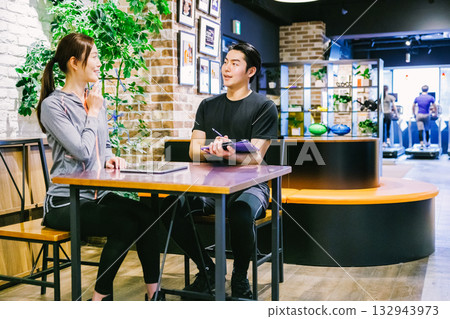 一位女士在健身房收到會員訊息 一位女士在健身房收到會員訊息 132943973