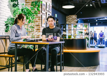 一位女士在健身房收到會員訊息 132943993