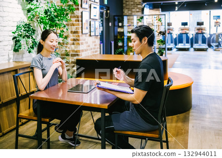 A woman receiving membership information at a sports gym 132944011