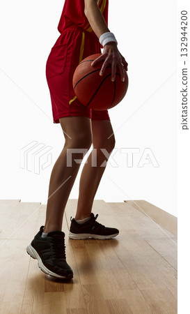 Female athlete in red uniform dribbling basketball with firm control 132944200