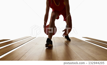 Female athlete dribbling basketball with focus and control on wooden floor Female athlete dribbling basketball with focus and control on wooden floor 132944205