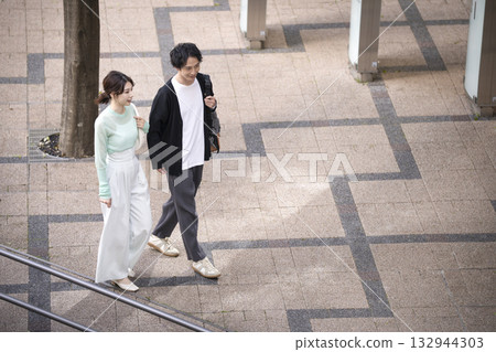 Men and women in their 30s walking around town 132944303