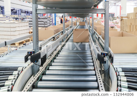 packing line in a logistics warehouse. conveyor belt in a modern production line packing line in a logistics warehouse. conveyor belt in a modern production line 132944806