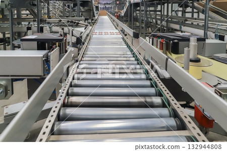 packing line in a logistics warehouse. conveyor belt in a modern production line packing line in a logistics warehouse. conveyor belt in a modern production line 132944808